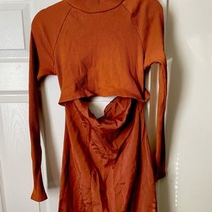 Long length orange/burgundy turtleneck dress with a peekaboo slit in the middle.